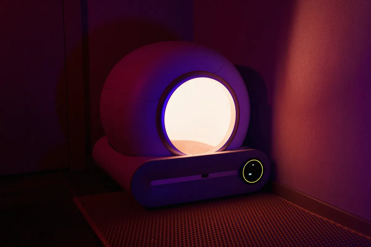 Une lampe ronde diffusant une lumière blanche dans une pièce aux tons violets