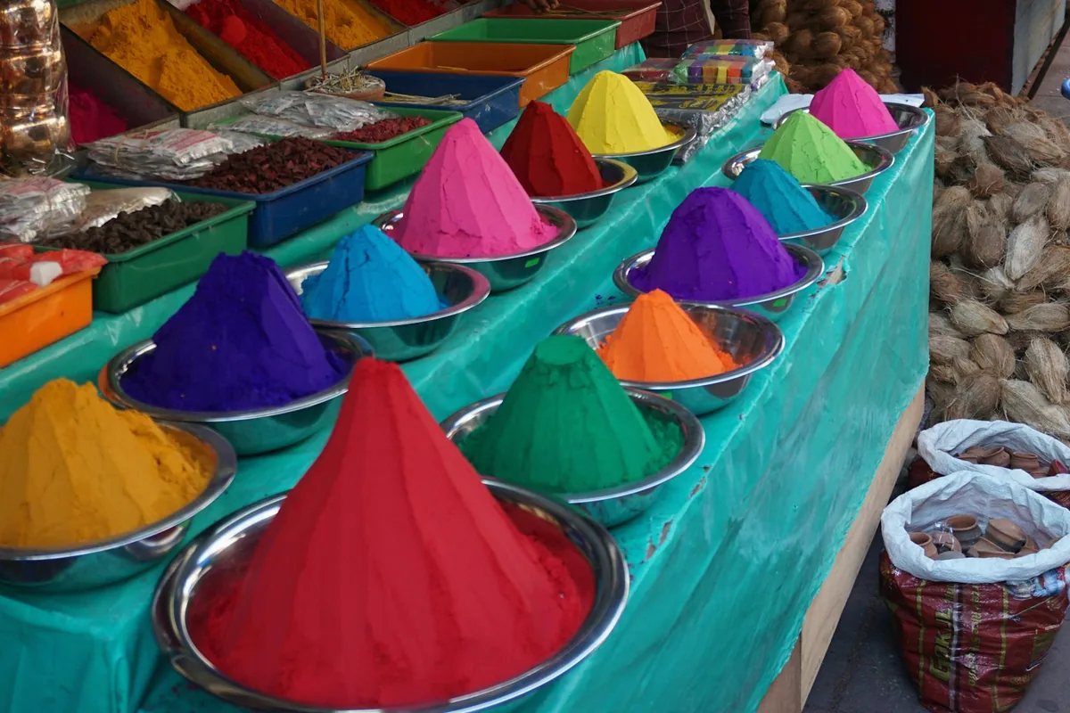 Des cônes de pigments aux couleurs vives dans des coupelles sur un étal